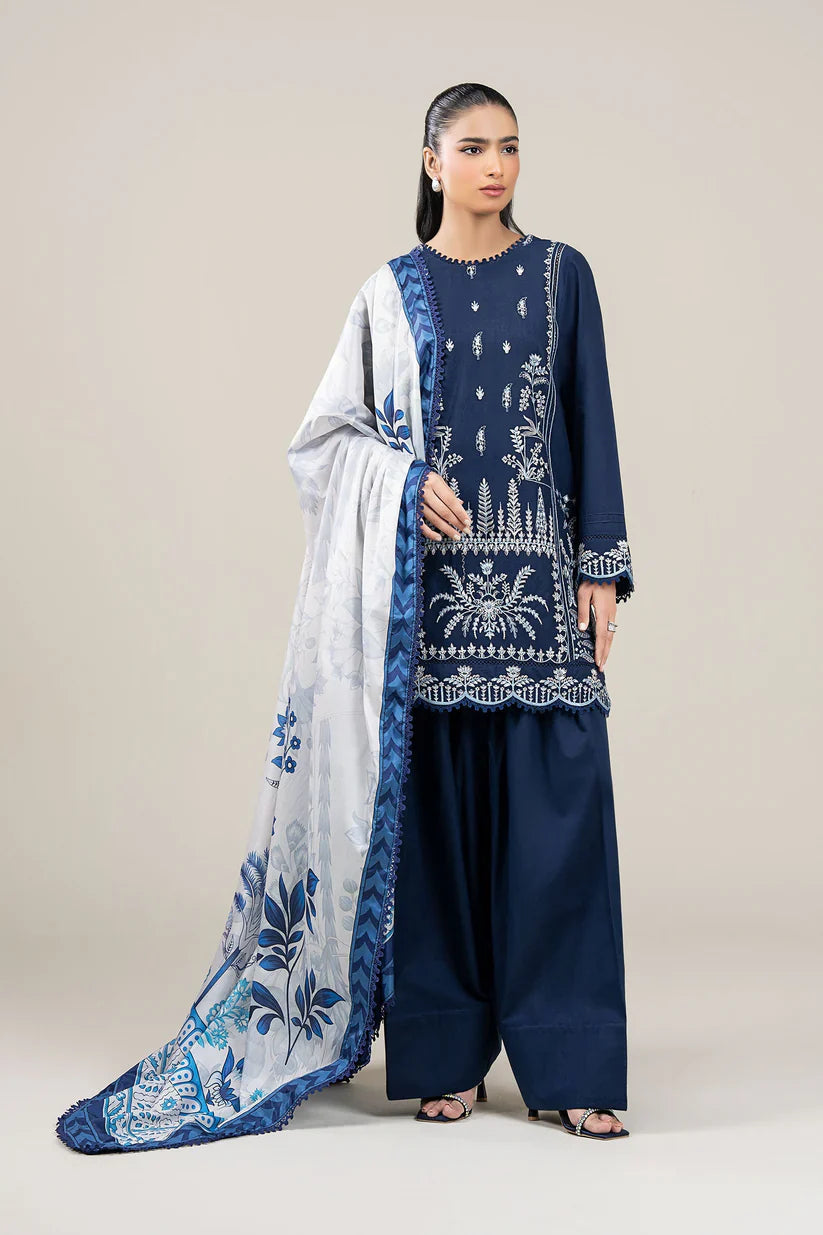 Woman wearing a navy blue embroidered outfit with a white dupatta on a plain background